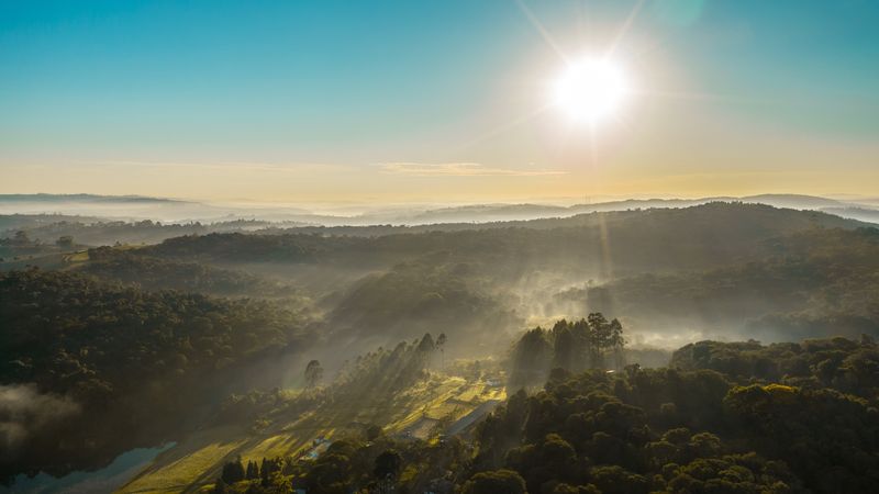 Vale com neblina e raios de sol ao amanhecer