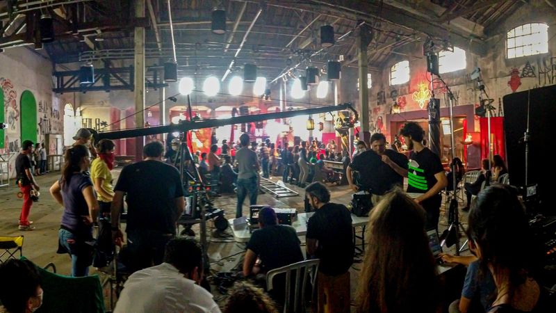 Grande set em galpão com grua, iluminação e equipe